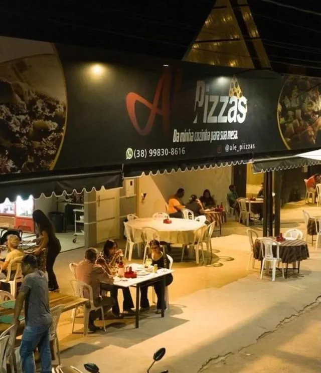 Fachada e salão da Alê Pizzas à noite