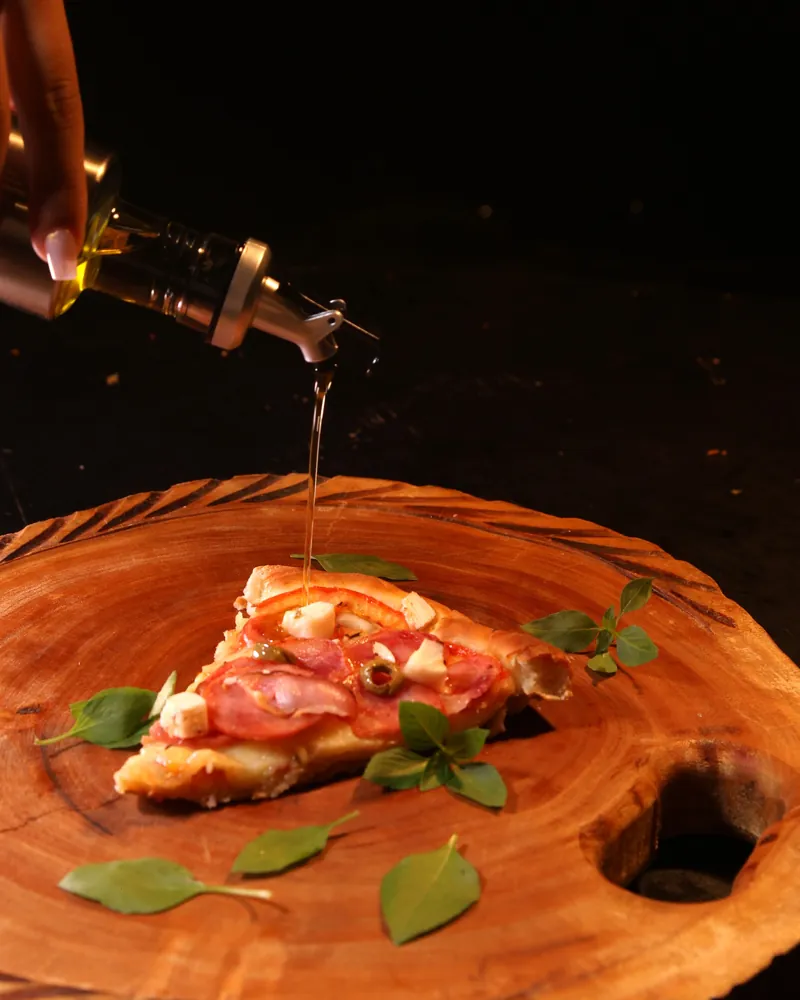 Fio de azeite na fatia de pizza